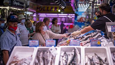 FILE - A customer pays for fish at the Maravillas market in Madrid, on May 12, 2022