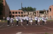 Graduates of two schools, bombed by Russian aircraft in March 2022 danced their last waltz in the yard of their ruined school buildings on Wednesday.