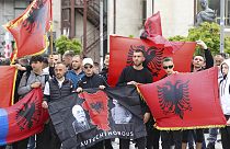 Manifestantes com bandeiras albanesas  na cidade de Mitrovica, Kosovo