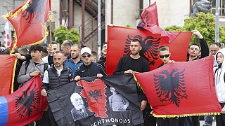 Manifestantes com bandeiras albanesas  na cidade de Mitrovica, Kosovo