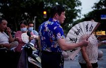 People use fans as they gather in a park amid a heatwave warning in Shanghai, China.