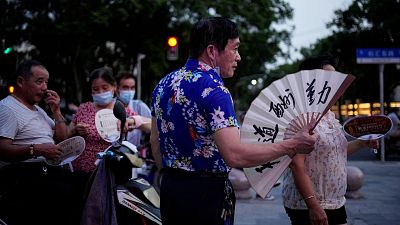 People use fans as they gather in a park amid a heatwave warning in Shanghai, China.