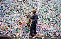 This photo taken on September 17, 2015 shows a Chinese labourer sorting out plastic bottles for recycling in Dong Xiao Kou village, on the outskirts of Beijing. 