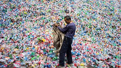 This photo taken on September 17, 2015 shows a Chinese labourer sorting out plastic bottles for recycling in Dong Xiao Kou village, on the outskirts of Beijing. 