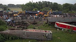People watch at the site where trains that derailed, in Balasore district, in the eastern Indian state of Orissa, Sunday, June 4, 2023.