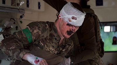 FILE: A wounded Ukrainian serviceman receives treatment at a stabilization point near Bakhmut, on May 20, 2023,