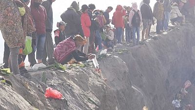 Los fieles arrojan sus ofrendas al cráter del volcán