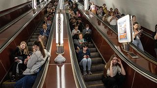 People take cover at a metro station during a Russian rocket attack in Kyiv.