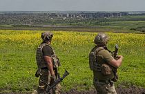 Ukrainian soldiers stand in their positions near Bakhmut, background, in the Donetsk region, Ukraine, Monday, June 5, 2023.