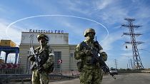 Russian troops guard an entrance of the Kakhovka Hydroelectric Station in Kherson region