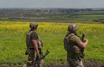 Zwei ukrainische Soldaten mit der Stadt Bachmut im Hintergrund
