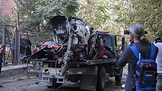 صورة أرشيفية، أفغان يتفقدون سيارة دمرتها قنبلة مثبتة، كابول، أفغانستان.