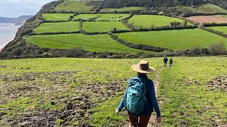 Susan Cunningham hikes near Salcombe Regis, part of the 630-mile South West Coast Path in southern England on April 25, 2023. 