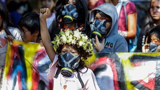یک کودک بومی برزیلی با پوشیدن ماسک ضد گاز در راهپیمایی شرکت کرده است