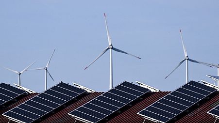 Solar panels of a building and wind turbines are pictured near Lichtenau, western Germany.