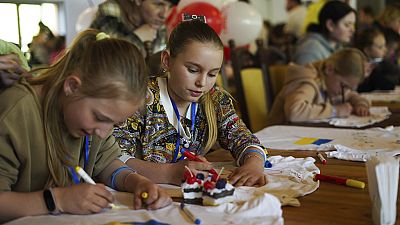 Olha Hinkina, second from left, attends an art session at the recovery camp for children and their mothers affected by the war near Lviv, Ukraine, Wednesday, May 3, 2023.