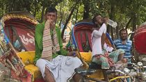 عمال يحاولون وقاية أنفسهم من موجة الحر في دكا