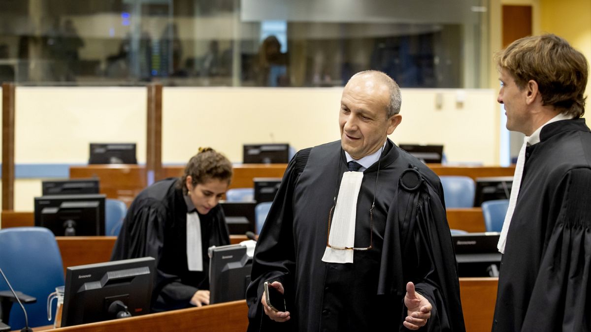 Felicien Kabuga ügyvédje az ügyésszel tárgyal a hágai bíróság épületében