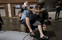 A woman is evacuated from a flooded neighborhood in Kherson, Ukraine, Wednesday, June 7, 2023 after the walls of the Kakhovka dam collapsed.