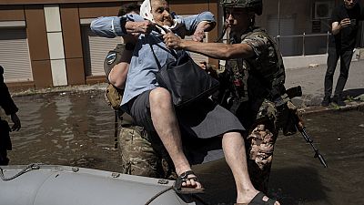 A woman is evacuated from a flooded neighborhood in Kherson, Ukraine, Wednesday, June 7, 2023 after the walls of the Kakhovka dam collapsed.