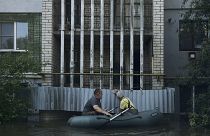 Residents in a small boat in the flooded region.