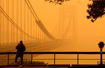 A Man talks on his phone as he looks through the haze at the George Washington Bridge in New Jersey 