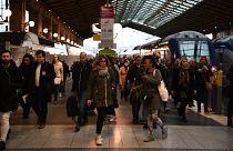 Des voyageurs se promènent à la Gare du Nord à Paris.