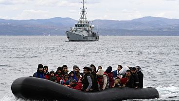 Migranti arrivano con un gommone accompagnato da una nave di Frontex sull'isola greca di Lesbo, il 28 febbraio 2020.