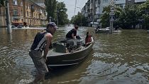 Des personnes avec des animaux de compagnie sont évacuées sur un bateau d'un quartier inondé à Kherson, en Ukraine, le jeudi 8 juin 2023.