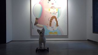 A robotic terrier with fluffy hair analyses artworks thanks to Artificial Intelligence (AI).
