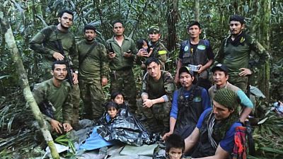 In this photo released by Colombia's Armed Forces Press Office, soldiers and Indigenous men pos with the four Indigenous brothers found in the Amazon.