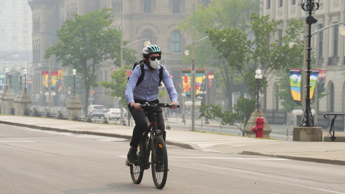 Un hombre circula entre el humo de los incendios forestales que llega a las ciudades en Canadá. 