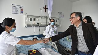 A kolumbiai elnök és az ápolónőt, aki az egyik gyermeket ápolja a Bogotában lévő katonai kórházban