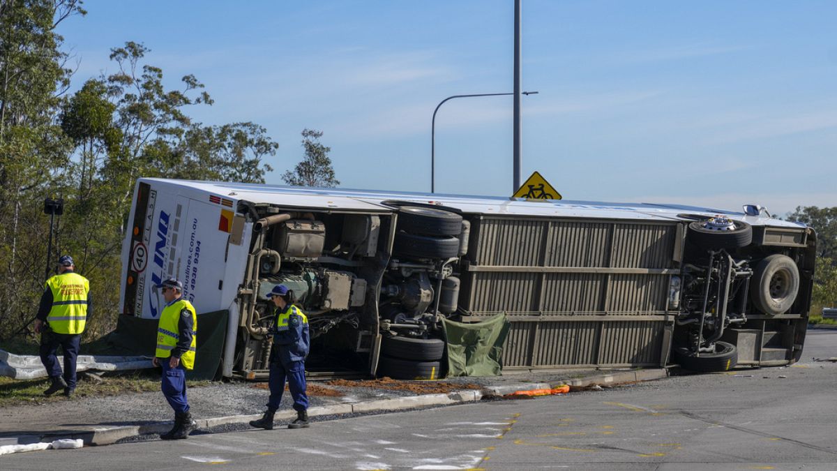 Police inspect underside of bus that rolled in Hunter Valley, Australia