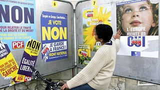 Joven vê os posters de campanha em França