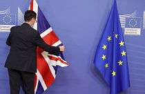 Un membre du protocole de la Commission européenne ajuste le drapeau du Royaume-Uni