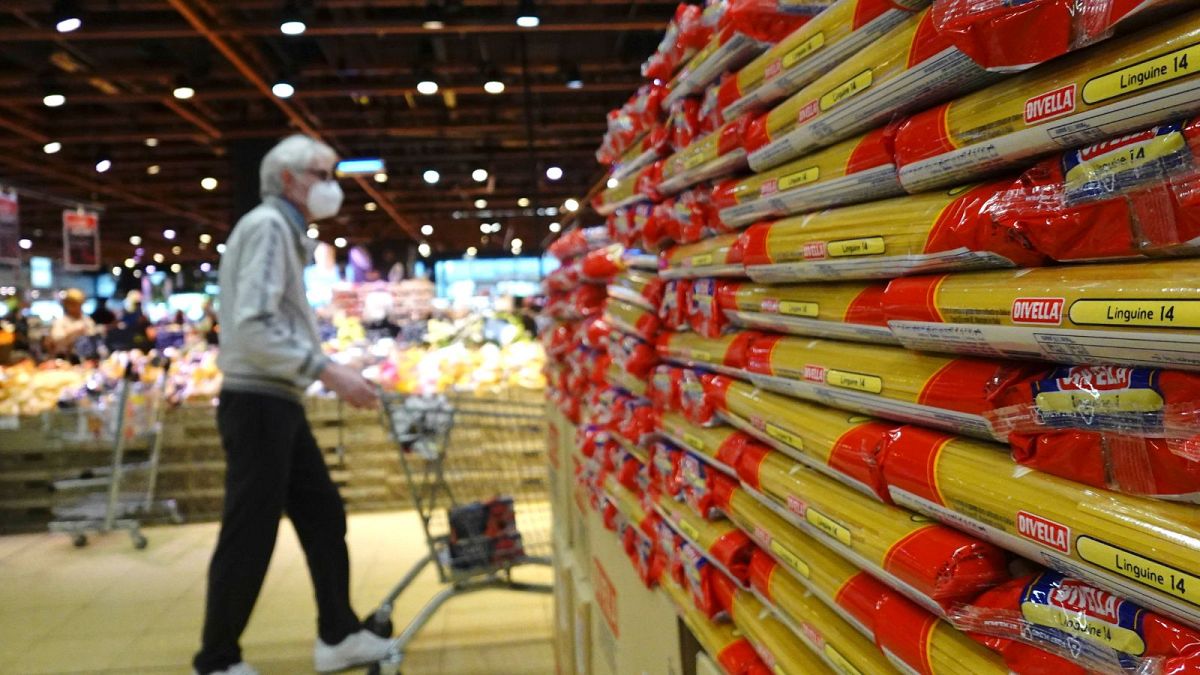 Los clientes observan paquetes de pasta a la venta en un supermercado de Milán, norte de Italia