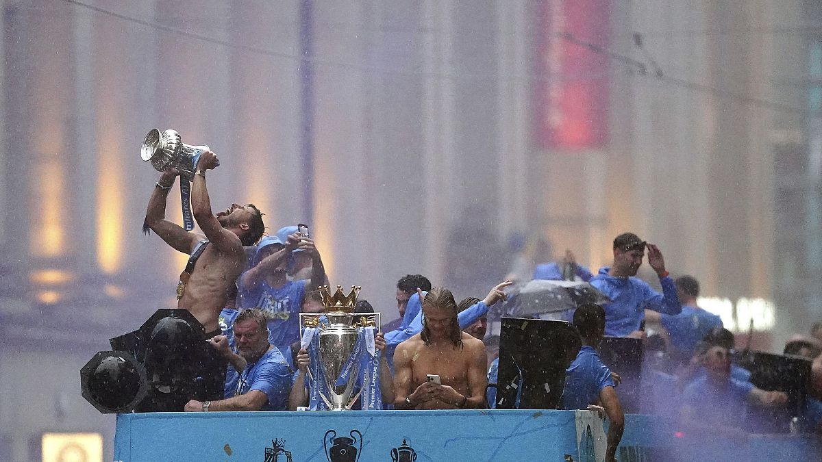 Manchester City's Ruben Dias and Erling Haaland celebrate during the parade to celebrate winning the Premier League, FA Cup and Champions League in Manchester, 12 June 2023