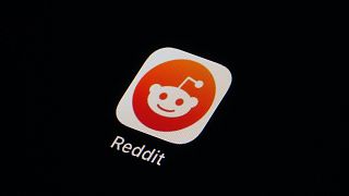 The Reddit app icon is seen on a smartphone.