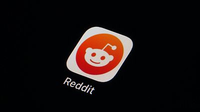 The Reddit app icon is seen on a smartphone.