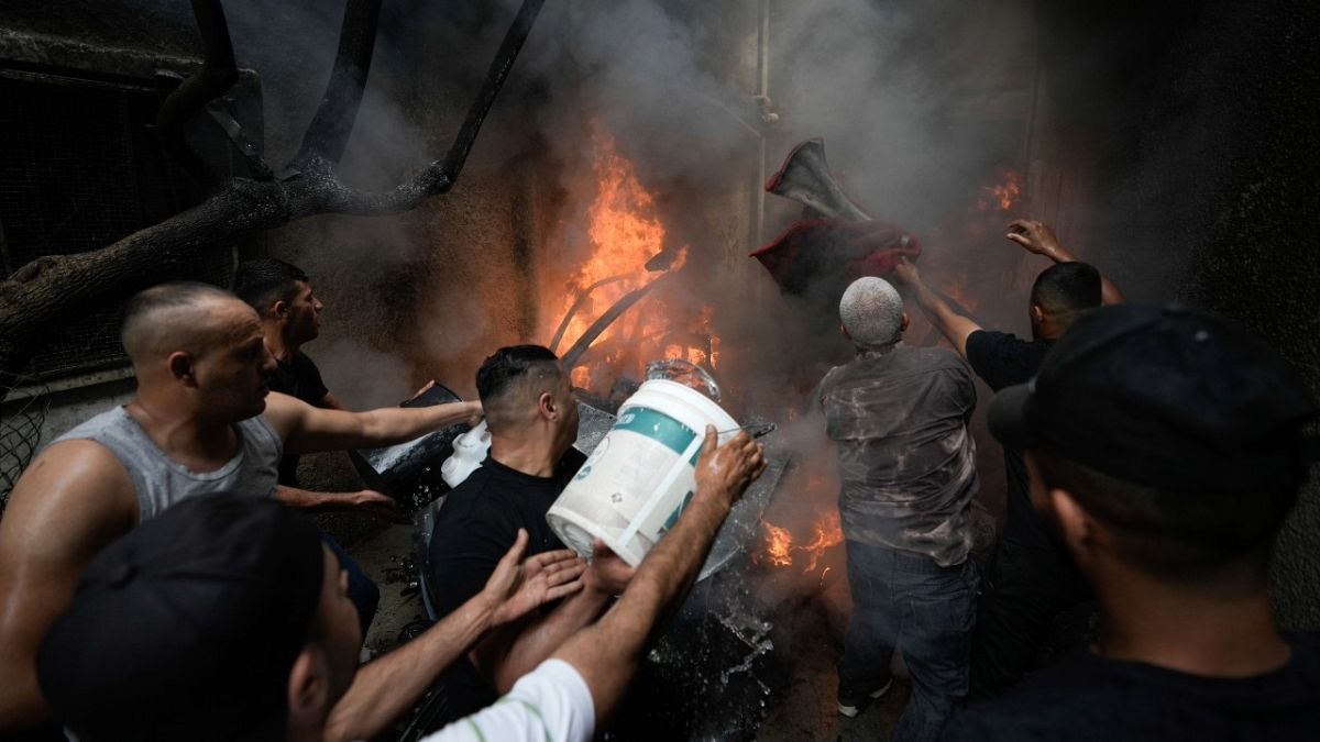 فلسطينيون يخمدون النيران بعد مداهمة الجيش الإسرائيلي مخيم بلاطة للاجئين في شمال الضفة الغربية المحتلة.