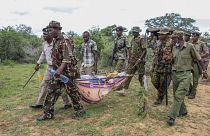 عناصر من الشرطة يحملون مع عدد من الأهالي جثث ضحايا طائفة دينية مستخرجة من القبور في قرية شاكهولا - كينيا. 2023/04/23
