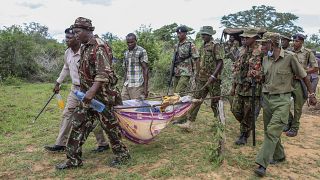 عناصر من الشرطة يحملون مع عدد من الأهالي جثث ضحايا طائفة دينية مستخرجة من القبور في قرية شاكهولا - كينيا. 2023/04/23