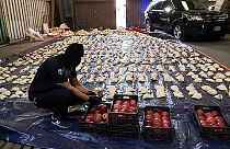 A Saudi customs officer opens imported pomegranates, as customs foiled an attempt to smuggle over 5 million Captagon pills in 2021.