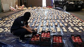 Um funcionário da alfândega saudita abre romãs importadas usadas para tentar contrabandear mais de 5 milhões de comprimidos de Captagon, em 2021.