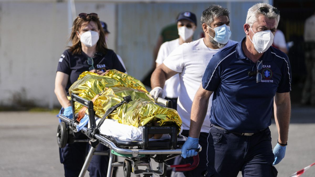 Paramédicos transportam um ferido para uma ambulância no porto de Kalamata, Grécia