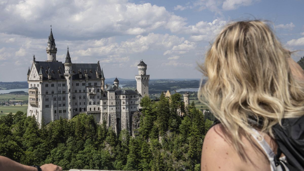 Une touriste regardant le château de Neuschwanstein, en Allemagne. 15 juin 2023