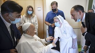 Papst Franziskus drückt einer Krankenschwester die Hand