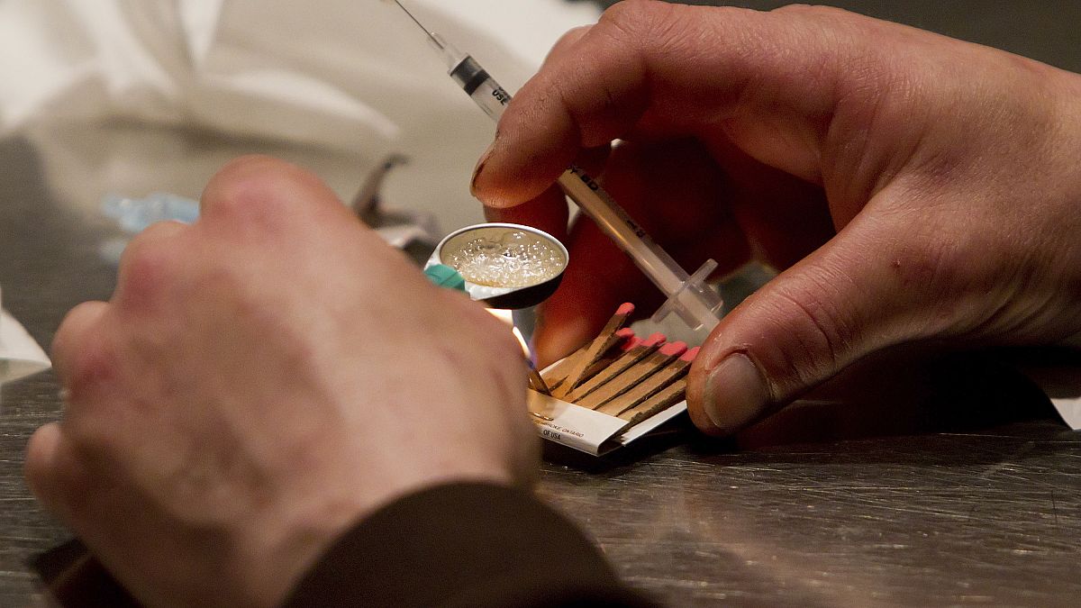 A man prepares drugs in a syringe.
