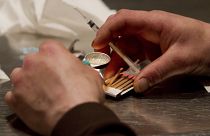 A man prepares drugs in a syringe.